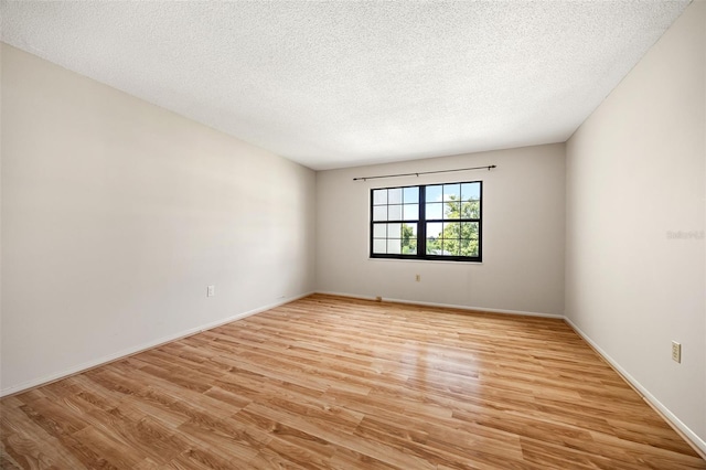 spare room featuring a textured ceiling and light hardwood / wood-style flooring