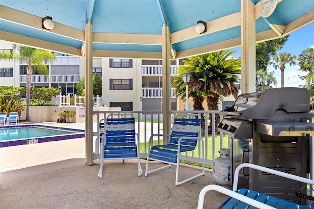 view of patio with a community pool and area for grilling