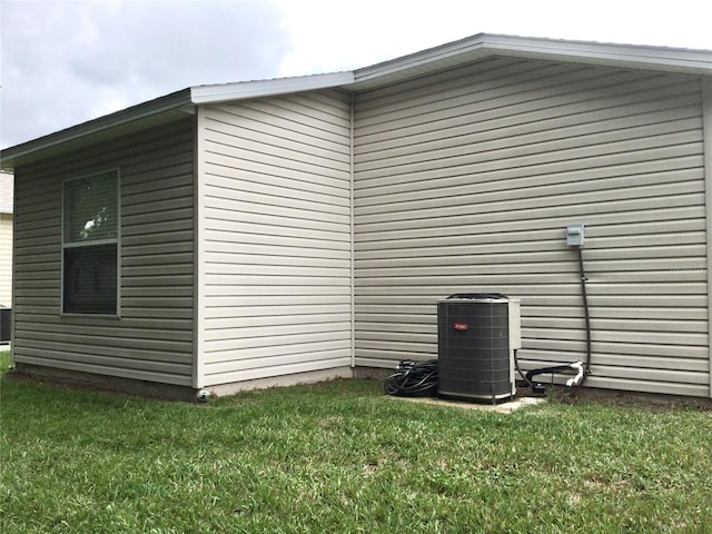 view of home's exterior featuring cooling unit and a yard