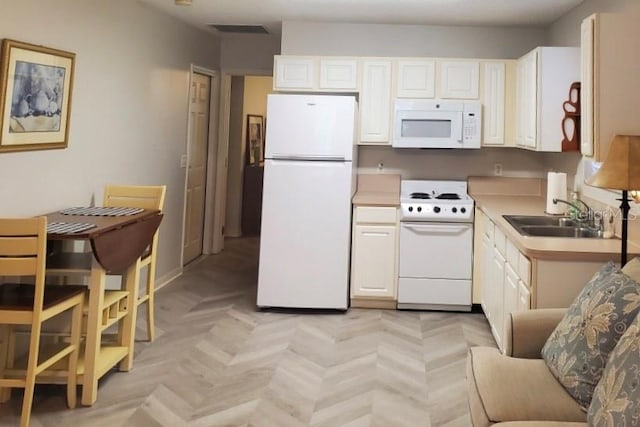 kitchen featuring white appliances, light parquet floors, and sink