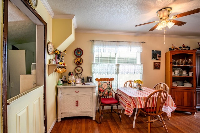 dining area with ceiling fan, dark hardwood / wood-style floors, ornamental molding, and a textured ceiling