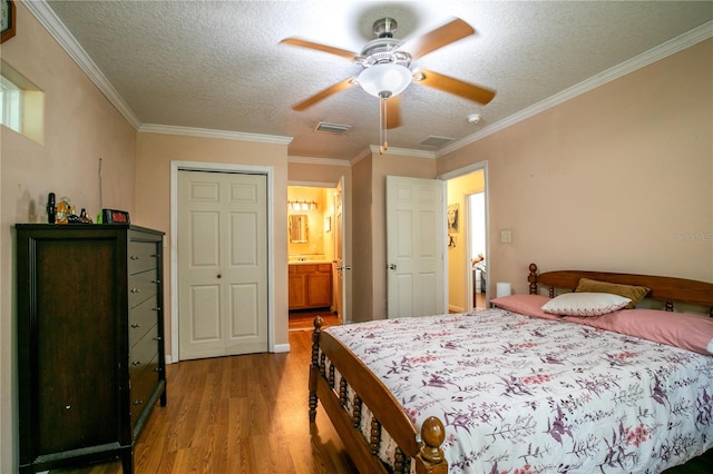 bedroom with crown molding, a textured ceiling, hardwood / wood-style flooring, and ceiling fan