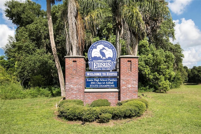 community / neighborhood sign featuring a lawn