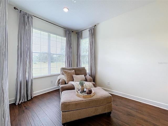 sitting room with a textured ceiling, dark hardwood / wood-style flooring, and a healthy amount of sunlight