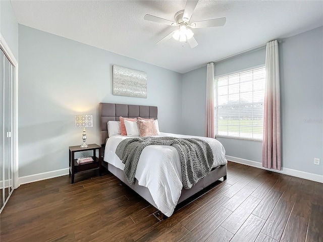 bedroom featuring ceiling fan, a closet, and dark wood-type flooring