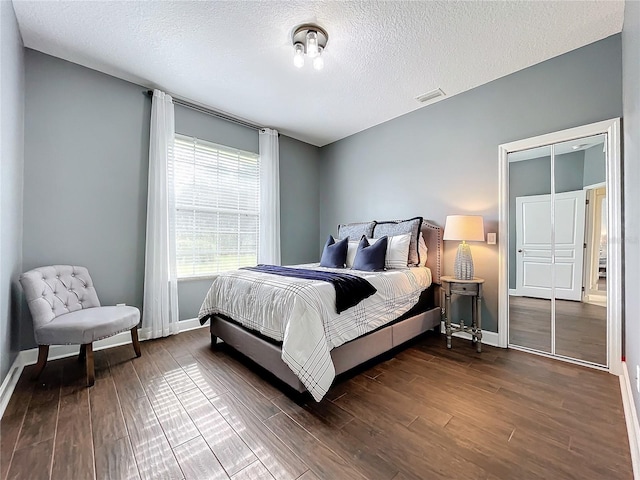 bedroom featuring a textured ceiling and dark wood-type flooring