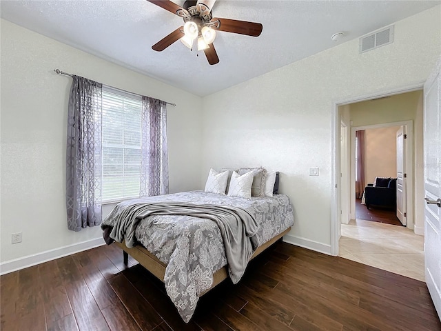 bedroom with ceiling fan, hardwood / wood-style flooring, and a textured ceiling