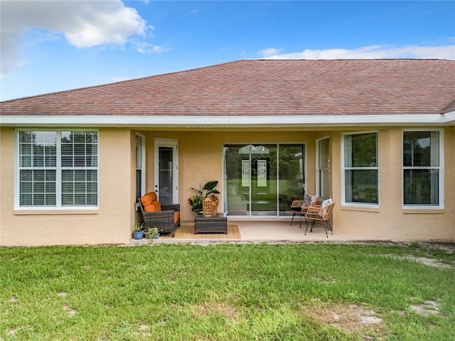 rear view of property with a lawn and a patio