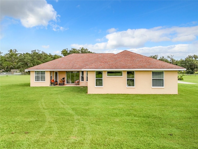 rear view of property with a yard