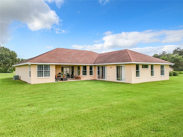 back of property featuring central AC, a patio area, and a yard