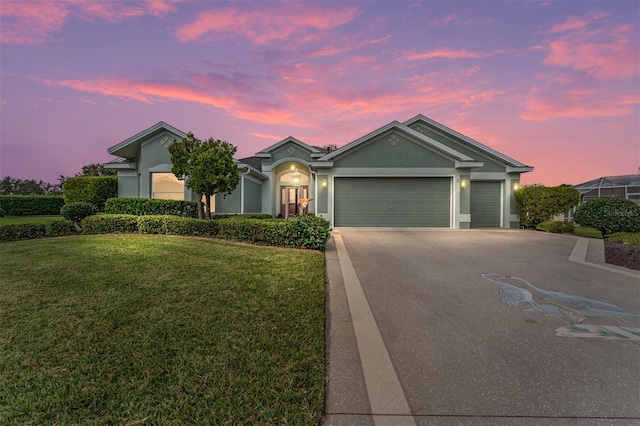 ranch-style house featuring a garage and a lawn