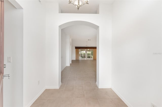 hallway featuring a chandelier and light tile patterned floors