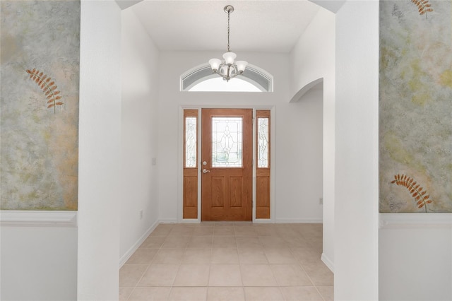 entryway with light tile patterned flooring and an inviting chandelier