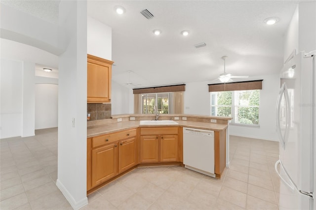 kitchen featuring kitchen peninsula, backsplash, sink, a textured ceiling, and white appliances