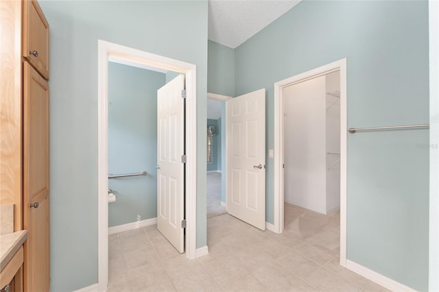 hall featuring a textured ceiling and light tile patterned floors