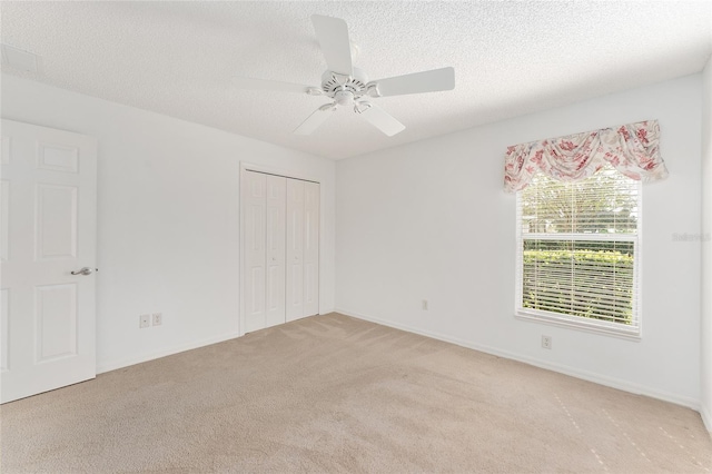 unfurnished room featuring a textured ceiling, light colored carpet, and ceiling fan