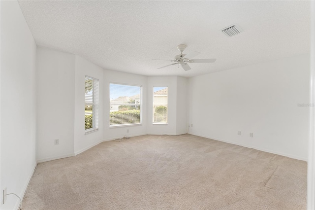 carpeted spare room with a textured ceiling and ceiling fan