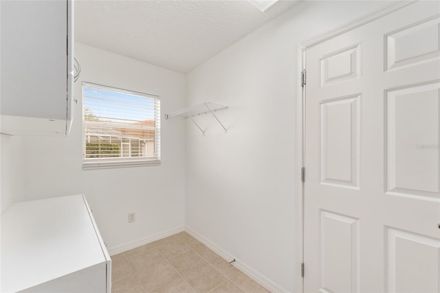 walk in closet with light tile patterned floors