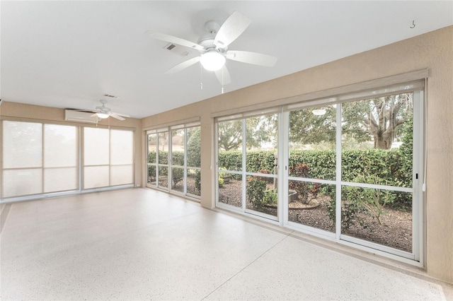 unfurnished sunroom featuring ceiling fan and a wall unit AC