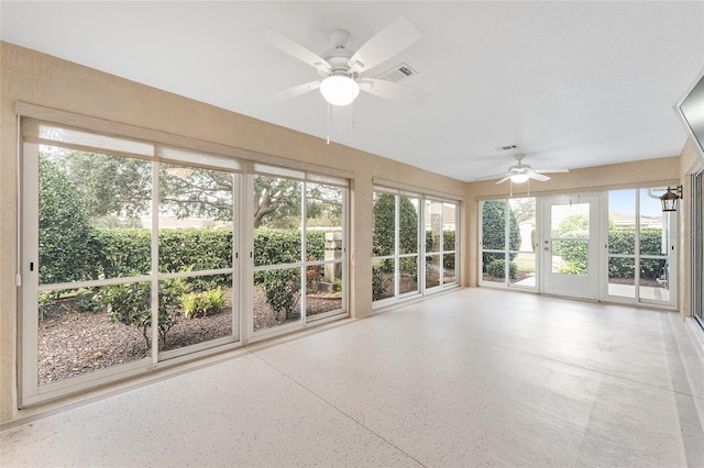 unfurnished sunroom featuring ceiling fan and plenty of natural light