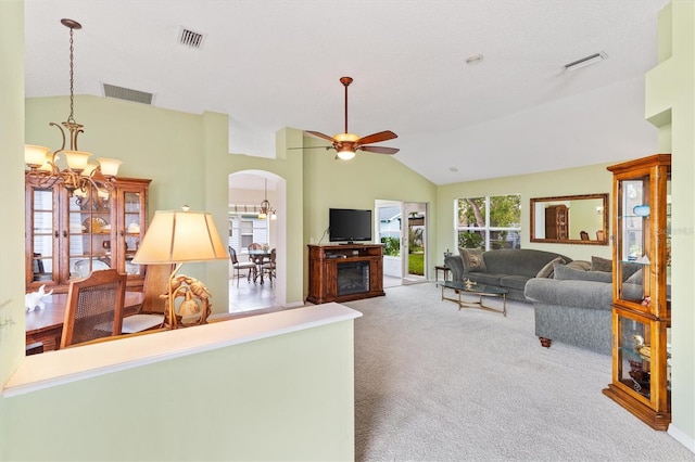 living room with carpet floors, ceiling fan with notable chandelier, lofted ceiling, and a fireplace