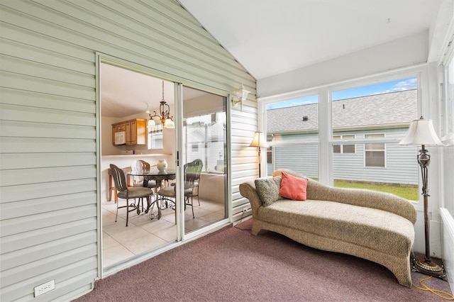 sunroom / solarium featuring a notable chandelier, vaulted ceiling, and plenty of natural light