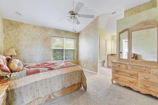 bedroom with a textured ceiling, lofted ceiling, light carpet, connected bathroom, and ceiling fan