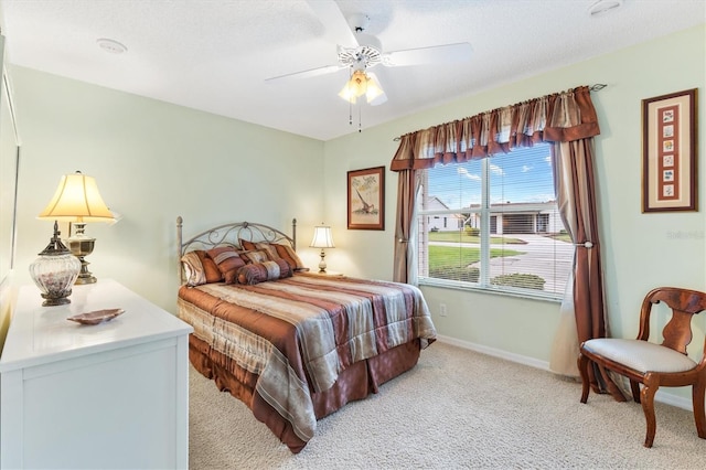 bedroom featuring a textured ceiling, ceiling fan, and light colored carpet