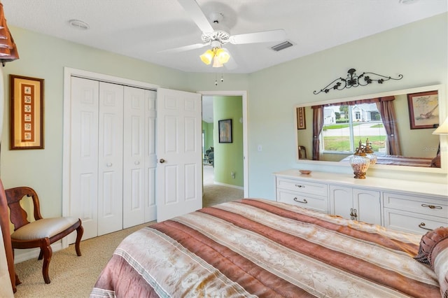 bedroom with a closet, ceiling fan, and light colored carpet