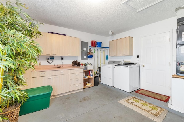 interior space featuring light brown cabinets, a textured ceiling, washer and dryer, and electric panel