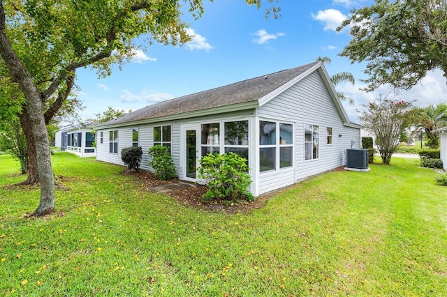 view of side of property featuring central AC unit and a yard