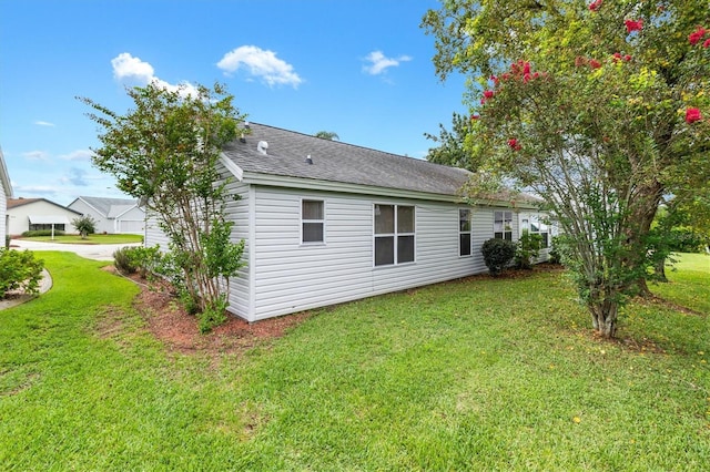 view of side of home with a yard