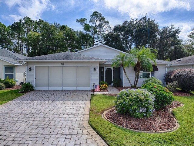 ranch-style home with a garage and a front lawn