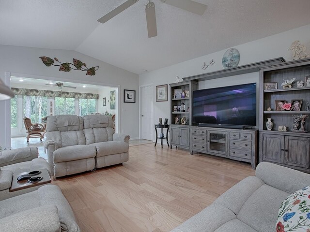 living room with lofted ceiling, ceiling fan, and light wood-type flooring