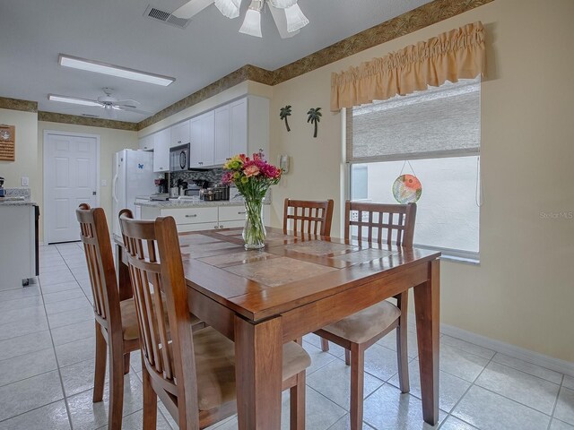 dining space with ceiling fan and light tile patterned flooring