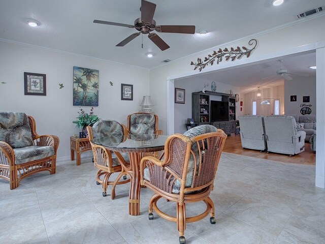 dining room featuring ornamental molding, vaulted ceiling, light wood-type flooring, and ceiling fan