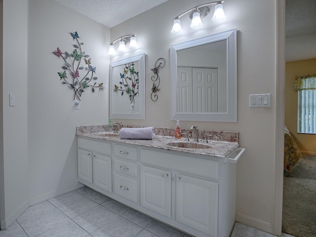 bathroom featuring tile patterned flooring, a textured ceiling, and vanity