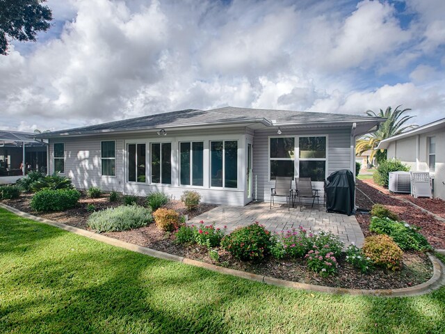 rear view of property with central AC, a lawn, and a patio area