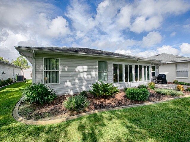 back of house featuring cooling unit, a lawn, and a patio area