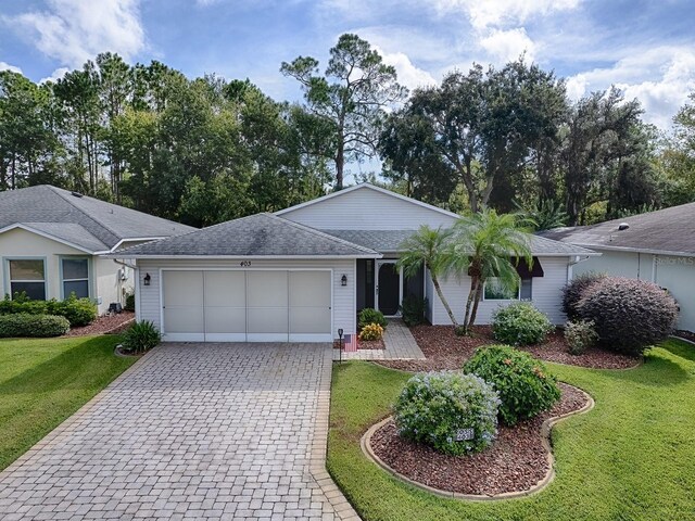 ranch-style house featuring a garage and a front lawn