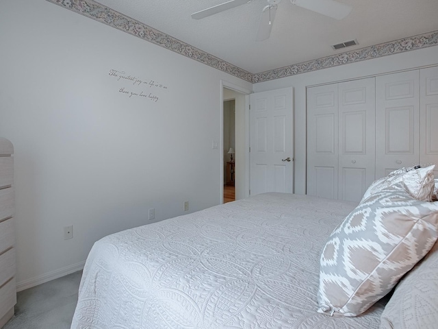 carpeted bedroom featuring a textured ceiling, ceiling fan, and a closet