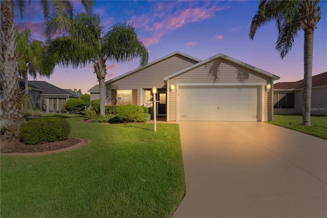 view of front of home with a garage and a lawn