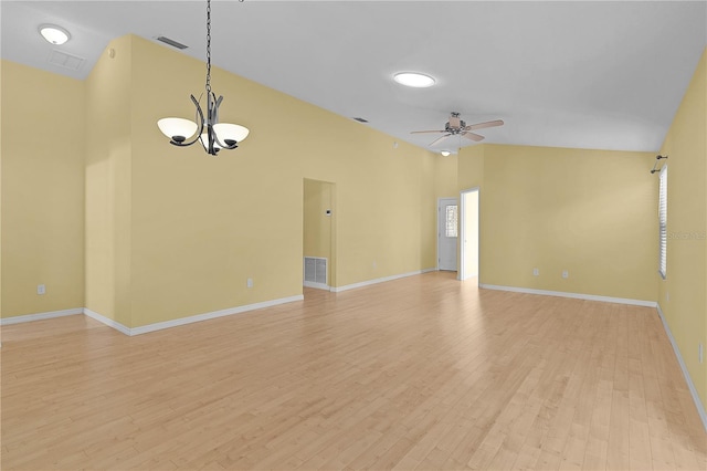 interior space with ceiling fan with notable chandelier, light hardwood / wood-style floors, and a high ceiling