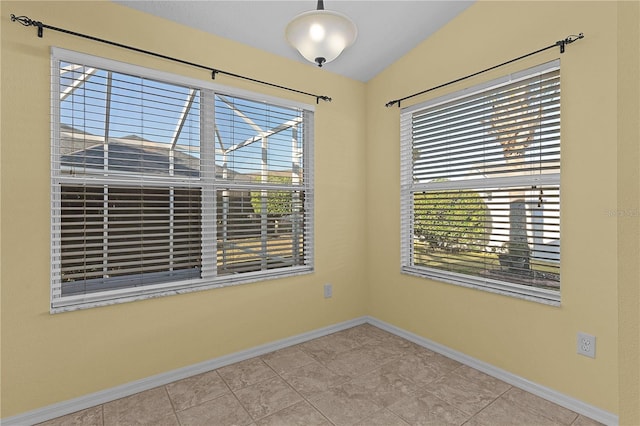 tiled spare room with lofted ceiling