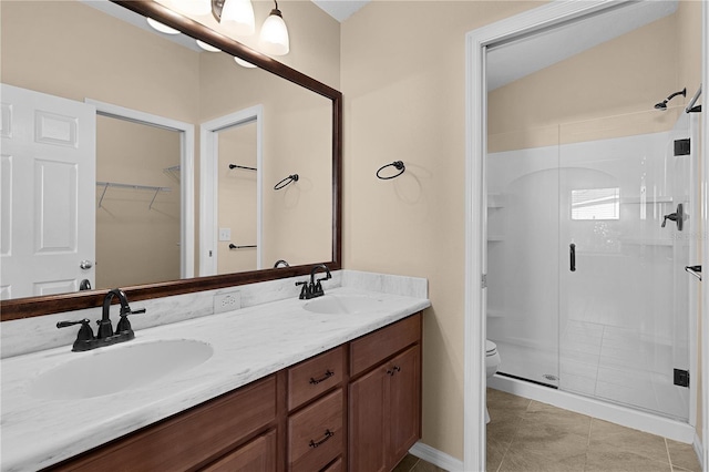 bathroom with tile patterned flooring, vanity, toilet, and a shower with door