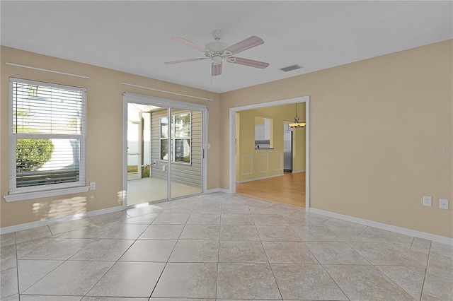 empty room featuring ceiling fan and light tile patterned floors