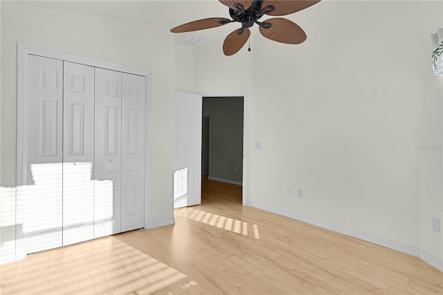 unfurnished bedroom featuring ceiling fan, light hardwood / wood-style floors, and a closet