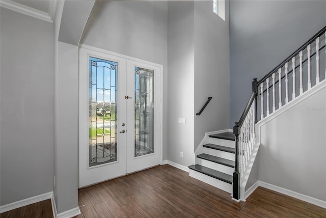 foyer featuring french doors, dark hardwood / wood-style floors, ornamental molding, and a healthy amount of sunlight