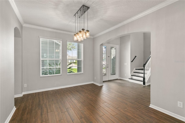 foyer with a textured ceiling, ornamental molding, dark hardwood / wood-style floors, and a chandelier