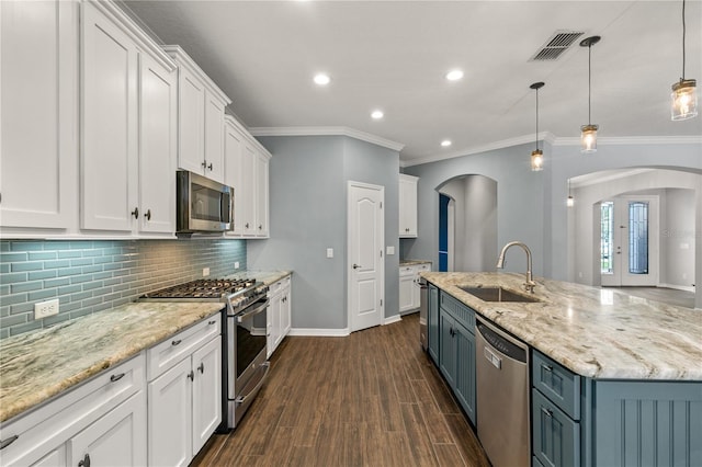 kitchen with sink, decorative light fixtures, dark wood-type flooring, white cabinetry, and appliances with stainless steel finishes